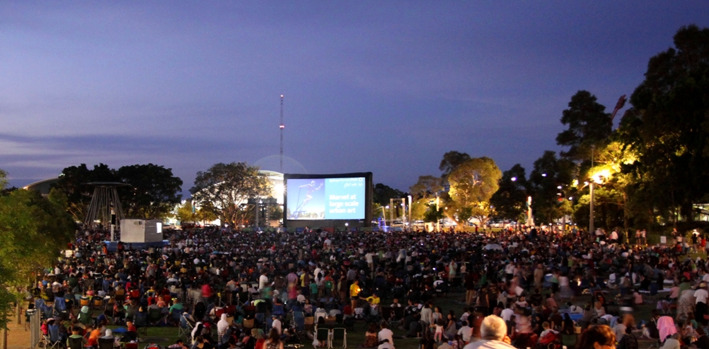 Le cinéma en plein air dans le parc Olympique de Sydney et ses 9000 spectateurs regardant l’écran géant gonflable. (AIRSCREEN classic 16m x 8m)